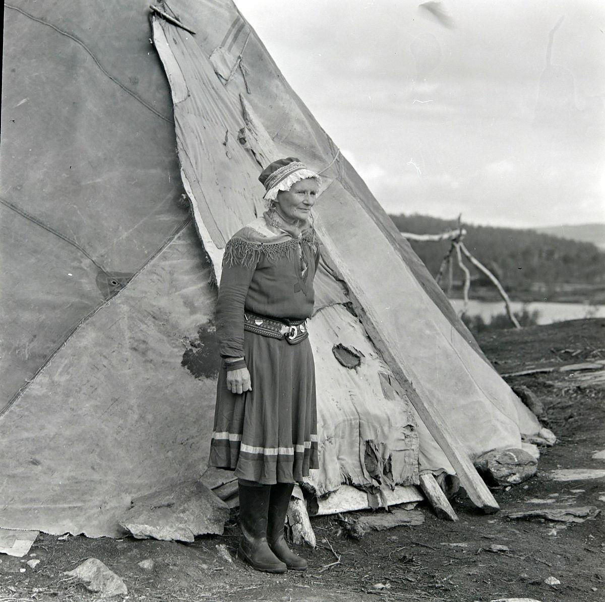 Samisk kvinne foran lavvo. Bilde tatt på svensk side - Klikk for stort bilde