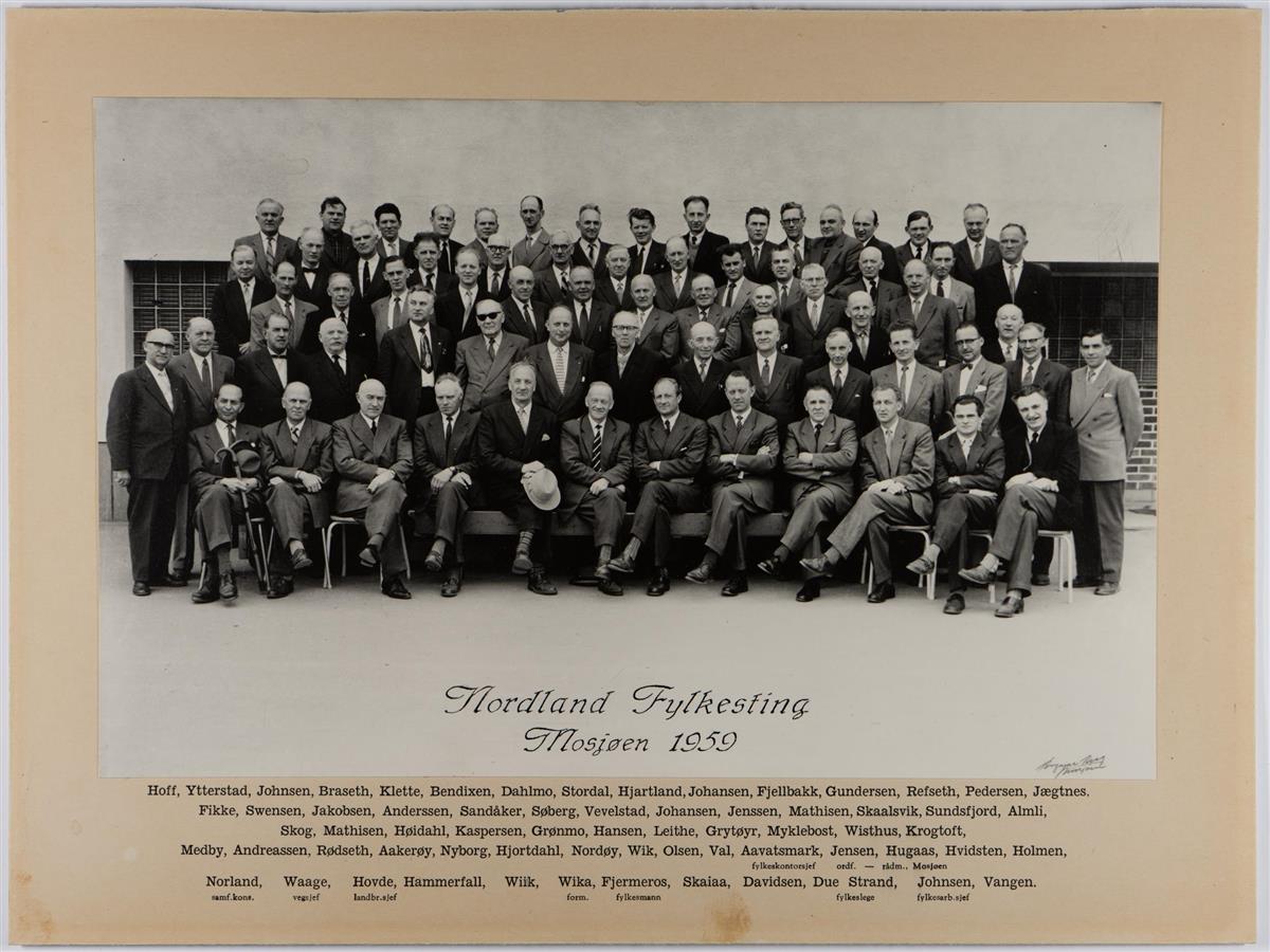 Gruppebilde i svart-hvit som viser 75 menn. Alle er kledd i dress. Under bildet står det "Nordland Fylkesting Mosjøen 1959". Under dette er etternavnene på de avbildede listet opp. På første rad sitter blant annet fylkesmannen i Nordland. - Klikk for stort bilde
