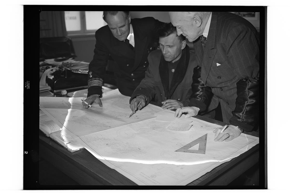 Bilde av tre menn på "Irtish" (Irtysj) som leser kart - Klikk for stort bilde